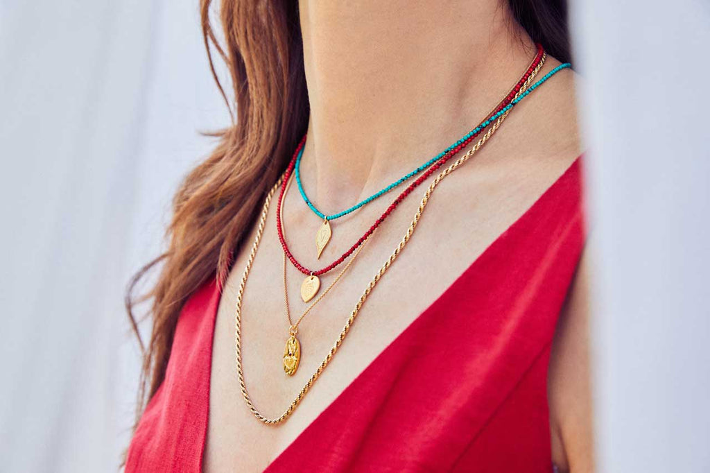 Emily Koliandri is wearing a combo of 4 different necklaces with germstones, silver 925 gold plated chain, combined with silver 925 gold plated charms.