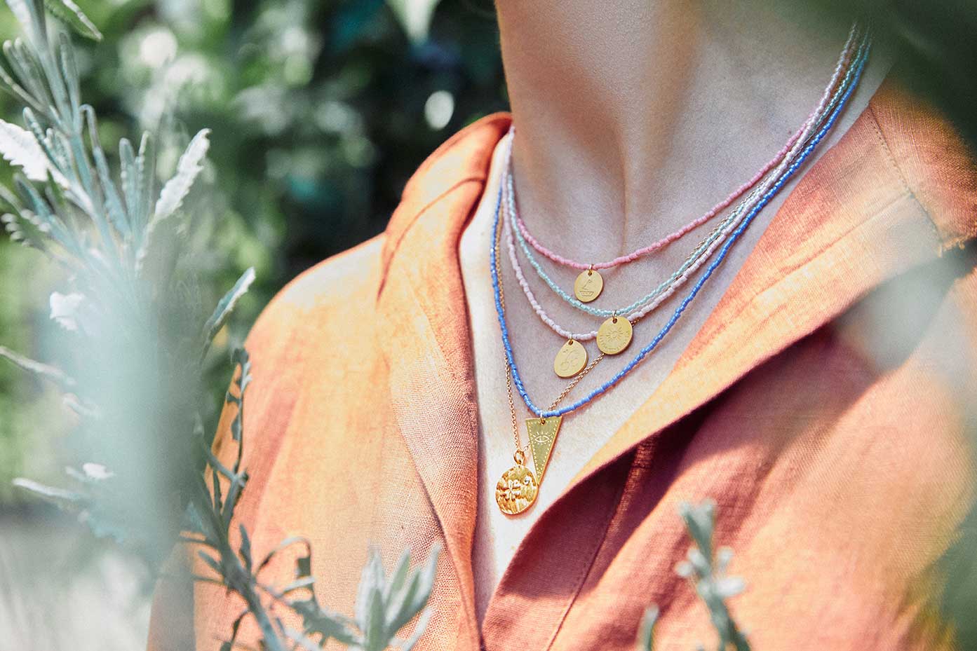 Emily Koliandri is wearing a combo of 5 different necklaces with miyuki beads, silver 925 gold plated chain and silver 925 gold plated charms in various shapes.