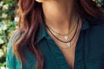 Load image into Gallery viewer, Emily Koliandri is wearing a combo in green tones of 3 different necklaces with crystals, semiprecious stones, silver 925 chain, combined with silver 925 charms in various shapes.
