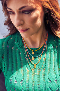 Emily Koliandri is wearing a combo of 4 different necklaces with miyuki beads, crystals, silver 925 gold plated chain, combined with silver 925 gold plated charms in various shapes. Also is wearing a silver 925 gold plated earring with a triangle silver 925 gold plated charm.