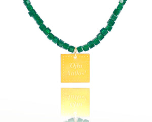 A necklace made of green emerald crystal beads and a squared silver 925 charm plated in gold 24K, with a message ´´όλα λάθος'' -'It's all wrong! ..