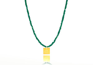 A necklace made of green emerald crystal beads and a squared silver 925 charm plated in gold 24K, with a message ´´όλα λάθος'' -'It's all wrong! .